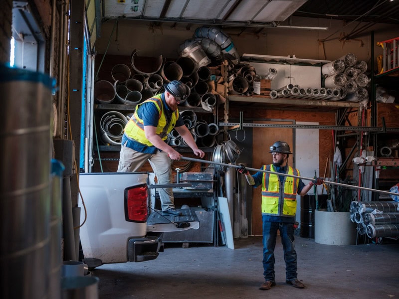 Tecton workers in construction gear unloading truck